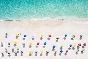 affordable-beach-towns: aerial shot of beach with colorful umbrellas