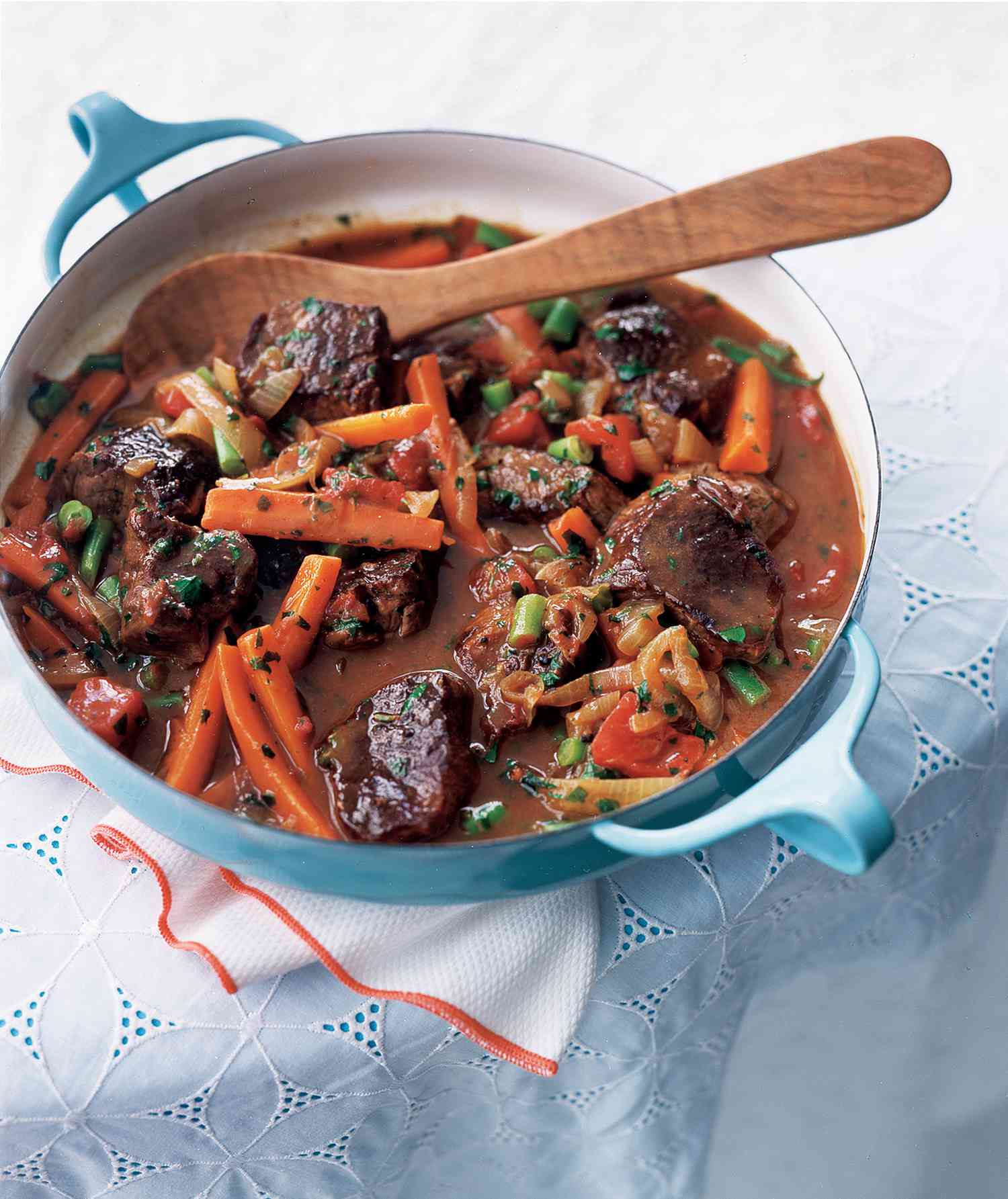 Quick Spring Lamb and Vegetable Stew in a Blue Pot With a Wooden Serving Spoon