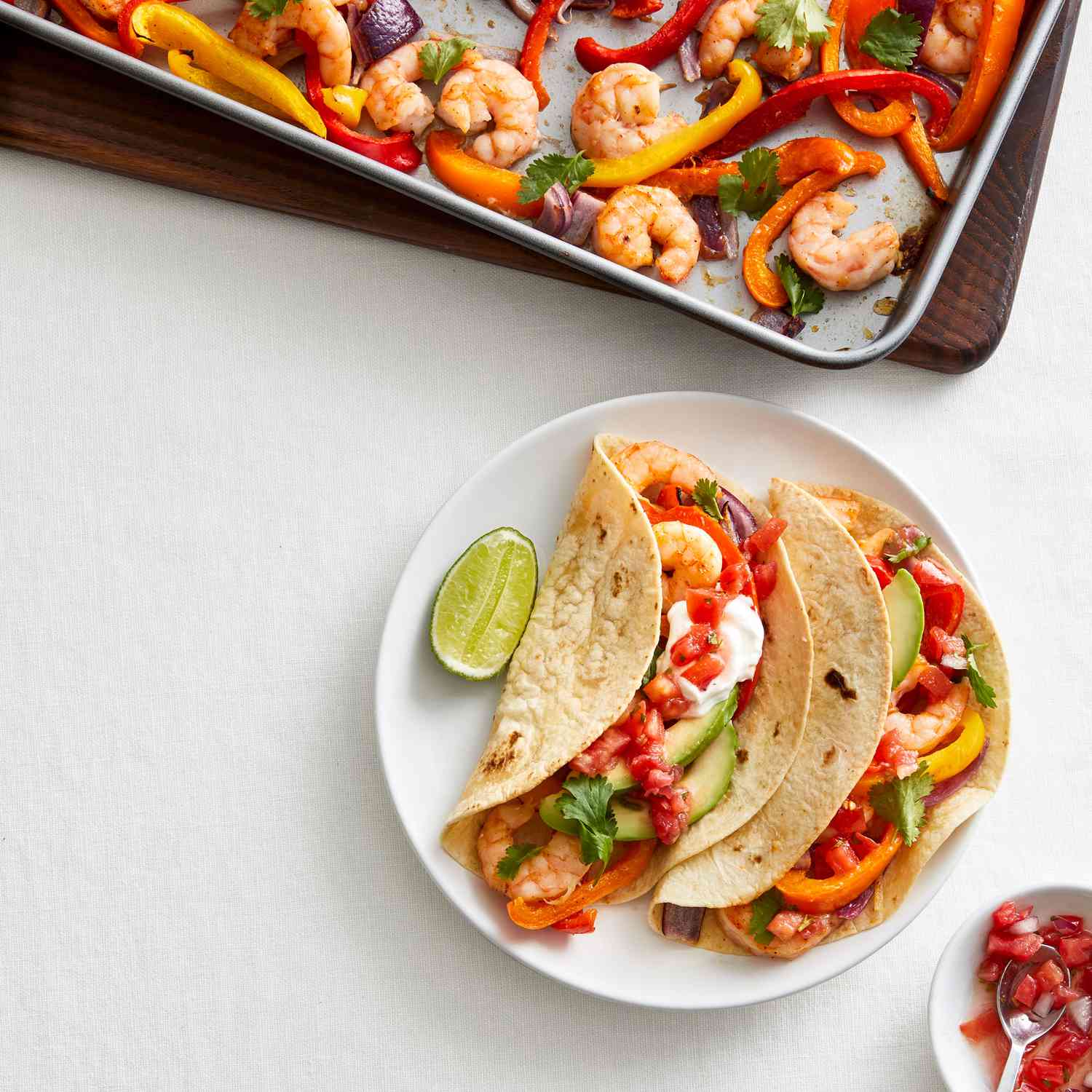 Sheet Pan Shrimp Faijitas With Two Assembled and Served on a White Plate