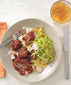 Slow-Cooker Chipotle Short Ribs With Tangy Cabbage Slaw Served Over White Rice on a White Plate With Metal Utensils and a Drink