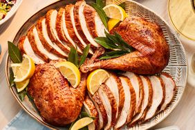 Overhead View of Smoky Maple Turkey Sliced and Served on Oval Dish with Lemon Wedges